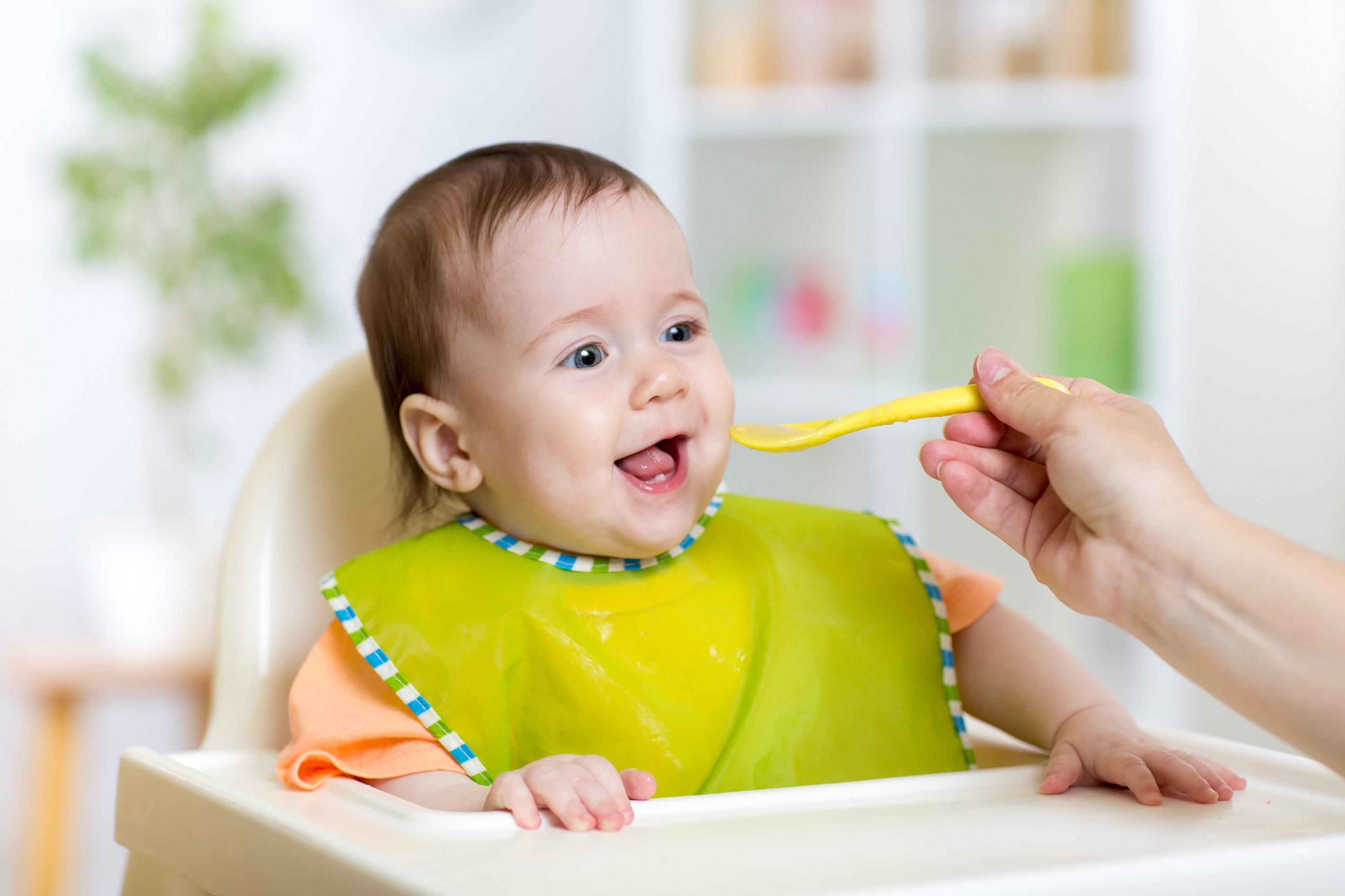 baby eating food on kitchen